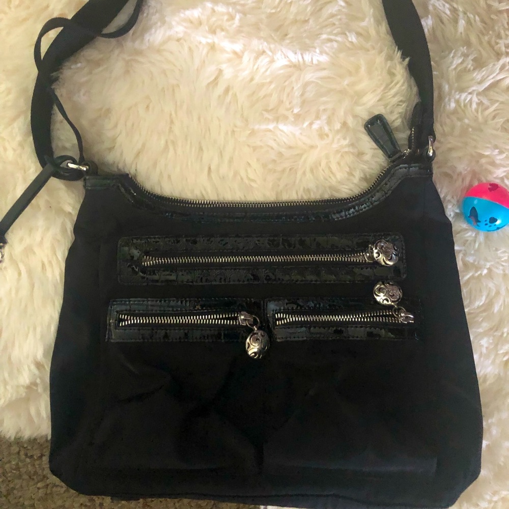 Black purse with adjustable shoulder straps .